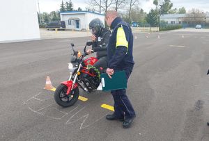 Policjant i uczestnik turnieju jadący motorowerem.